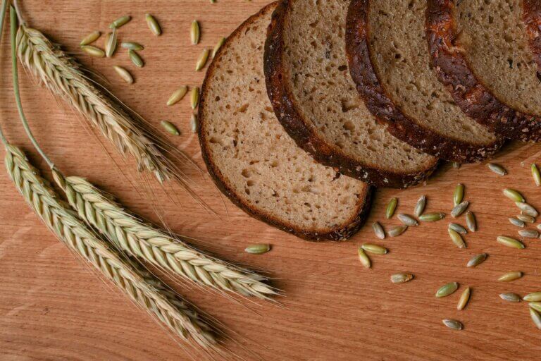 Sliced Bread on Brown Wooden Table With Stalks of Wheat and Wheat Berries