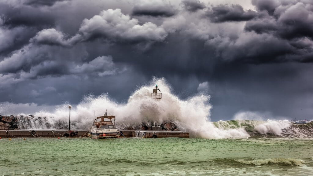 Storm Clouds and Waves Crashing Over a Boat on the Sea